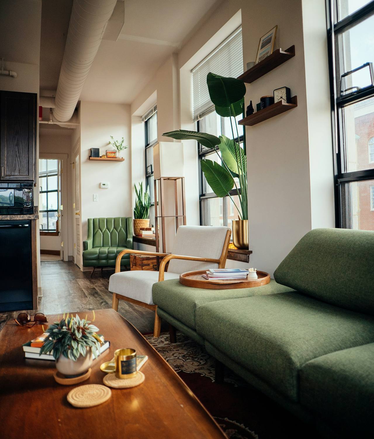 Salon lumineux aux tons verts et bois, dans un appartement